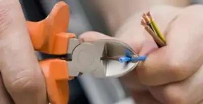 licensed electrician performing precise wire cutting and preparation during electrical service in Spokane, WA