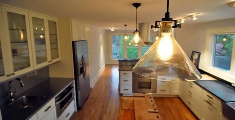 Residential electrician installing modern indoor light fixture in a home in Spokane, WA