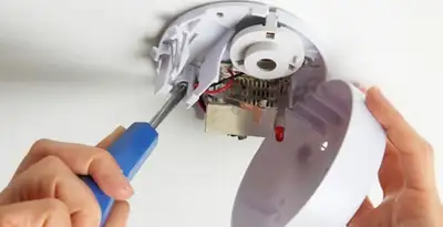 Certified technician wiring smoke detector during installation in Spokane, WA